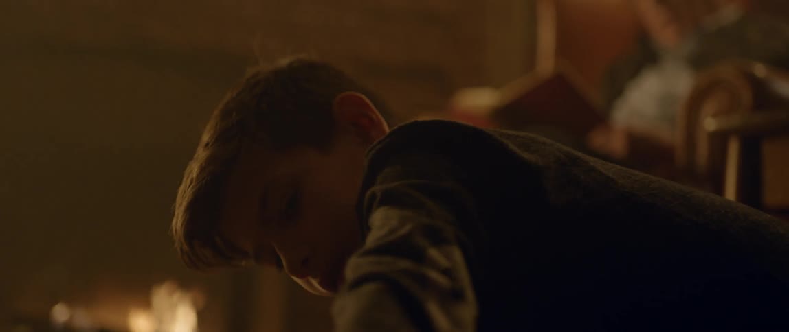 A boy is playing near a fireplace