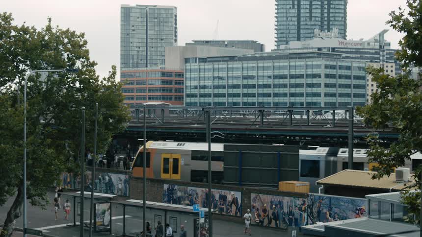 Train driving on the tracks near the city downtown