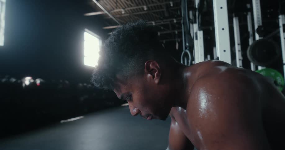 A man that is sitting in a gym after working out