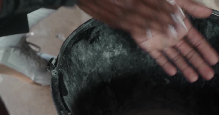 Strong sweaty muscular man rubs talcum on his hands before workout