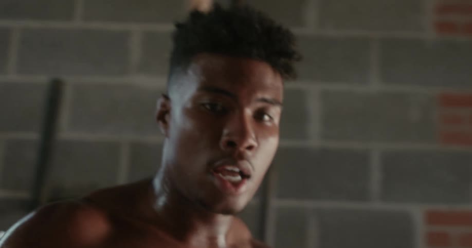 A man is covered in sweat as he moves from a piece of gym equipment