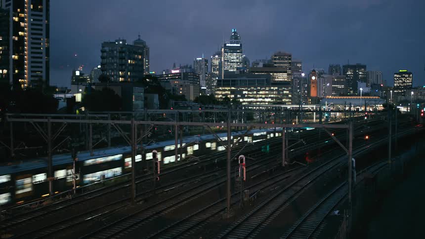 Illuminated high rise buildings and a train running on tracks