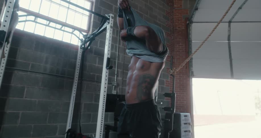 A man takes his shirt off as he prepares to exercise