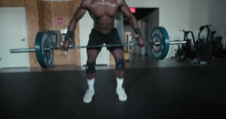 A man in a room exercising with a wall and window in the background