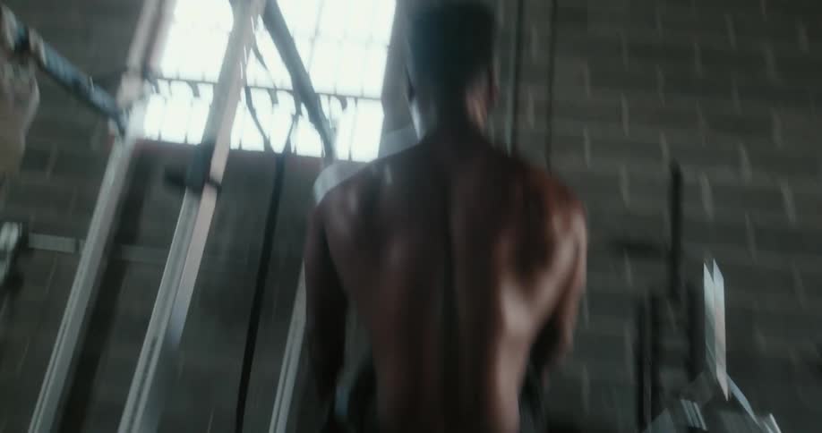 Shirtless muscular man does sit ups in gym