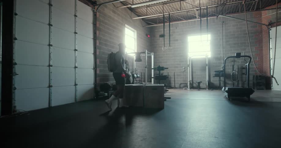 Man enters gym and puts down his bag on a table