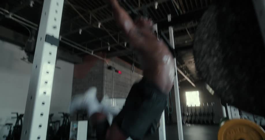 Strong muscular shirtless man working out on a gym