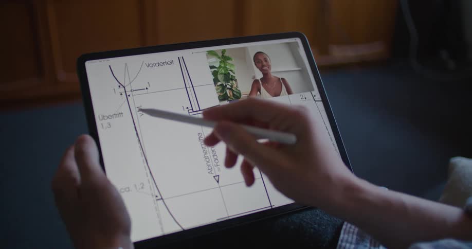A woman on the laptop is talking with someone looking at a diagram