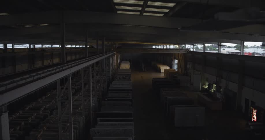 Lights turning on inside a warehouse filled with granite