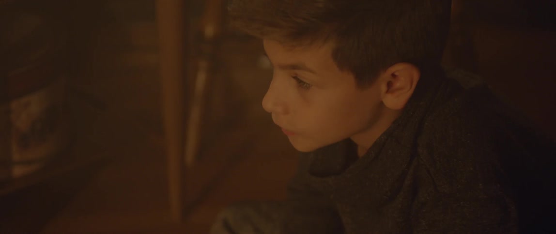 A boy looks up from what he is doing