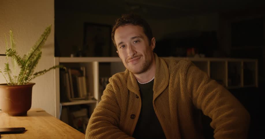 A man is sitting at a desk and smiling