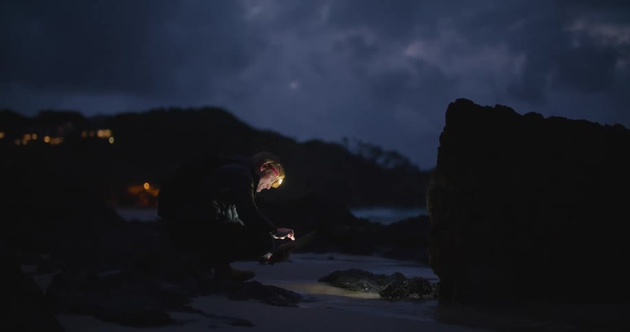 A man outdoors at night with a headlamp on