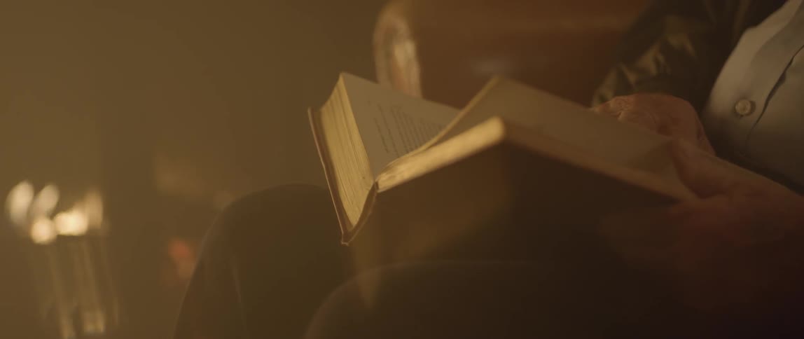 A person sitting turns the page of a book