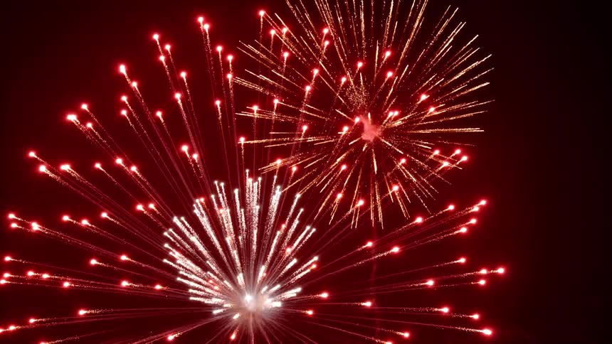 Fireworks display explode in night sky filling dark with expanding patterns of colored light