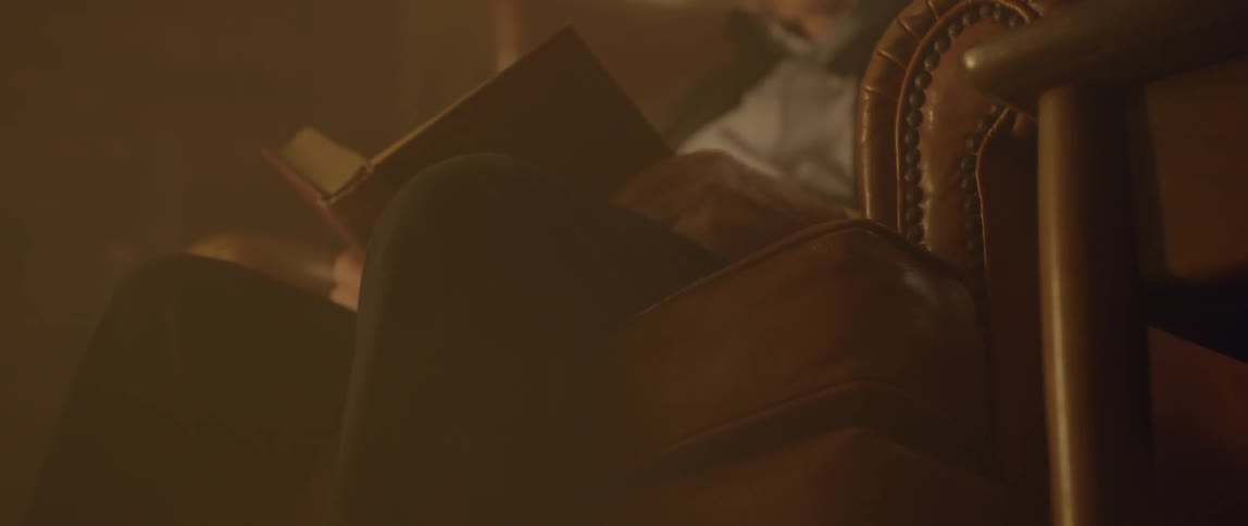 A man reads a book while sitting in a chair