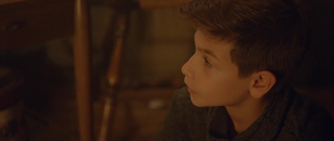 A little boy looks up toward a light