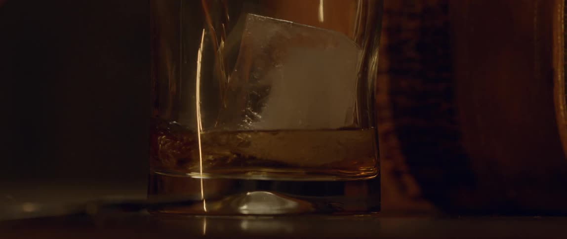 Water is poured into a cup with an ice cube in it