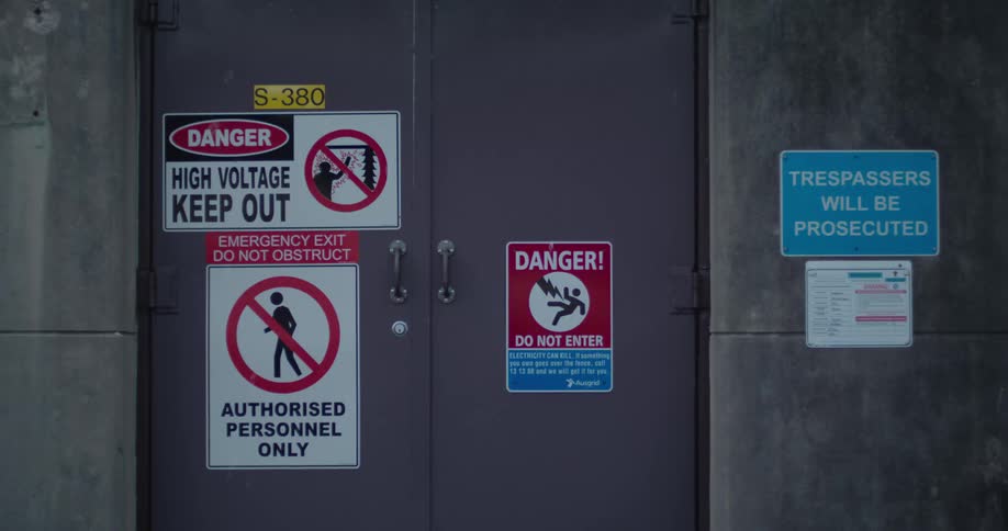 Multiple signs outside the private door of a business warns non authorized people to stay out