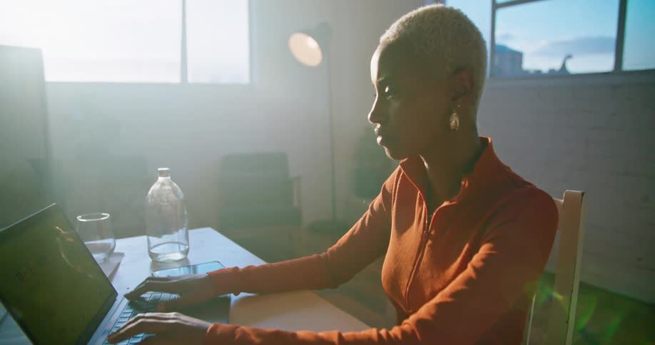 Young woman sitting at a desk in the office working on a laptop