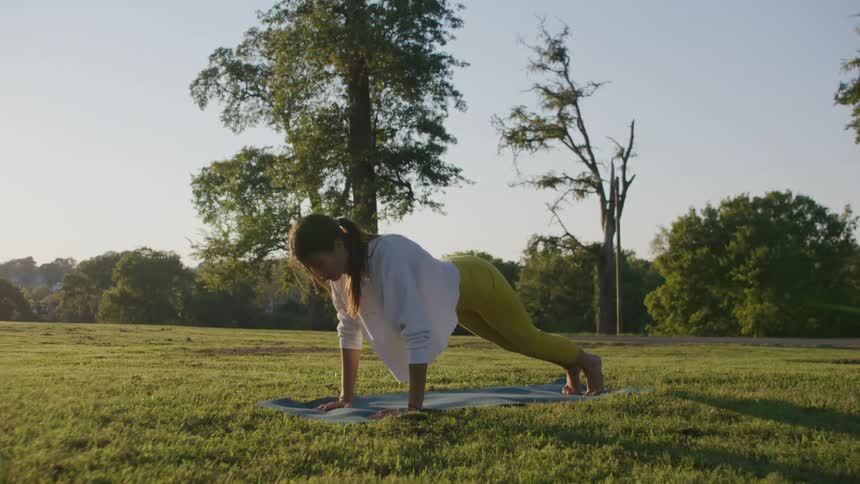 A woman is doing yoga on the field