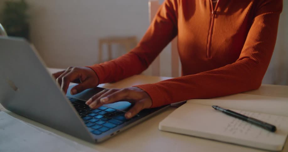 A woman typing on a laptop in a room