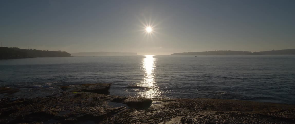 The coast with water rippling as the sun sets
