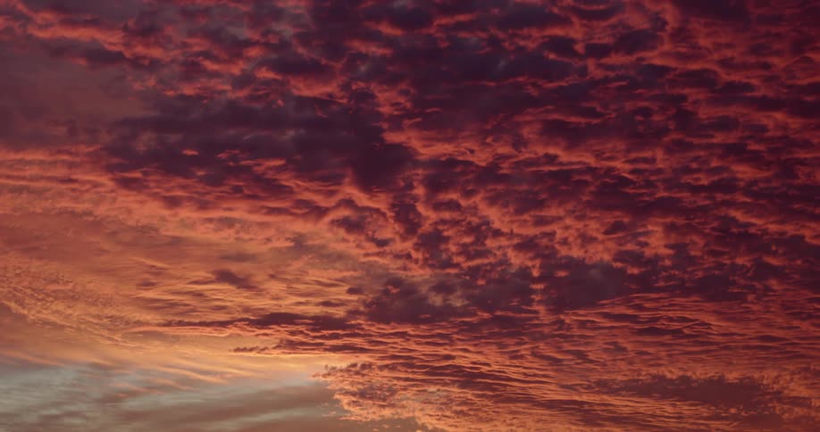 Deeply tinted red cloud formation moves slowly across the sky