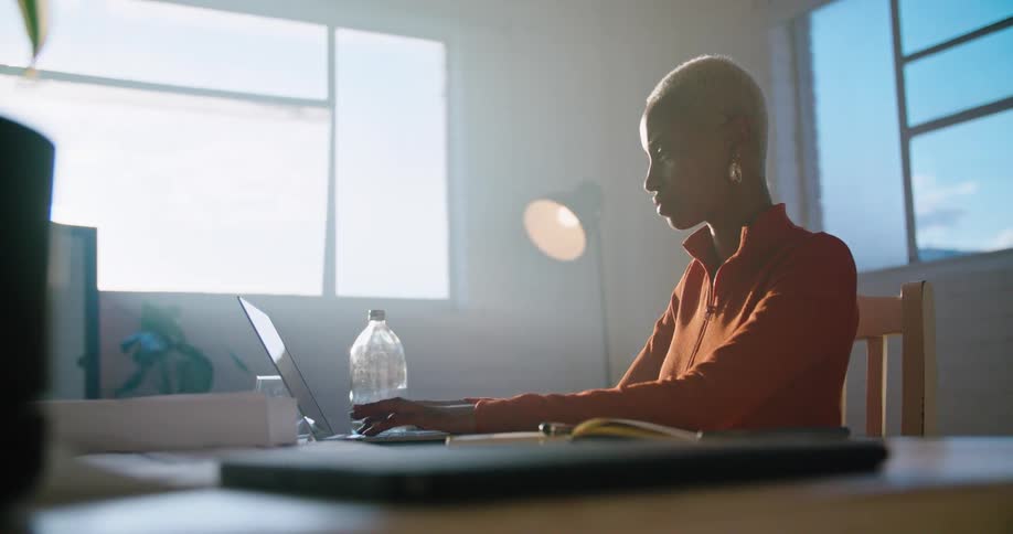 A woman typing on a laptop in a room