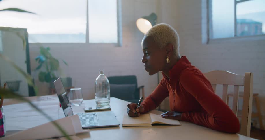 A woman is talking with someone on her laptop