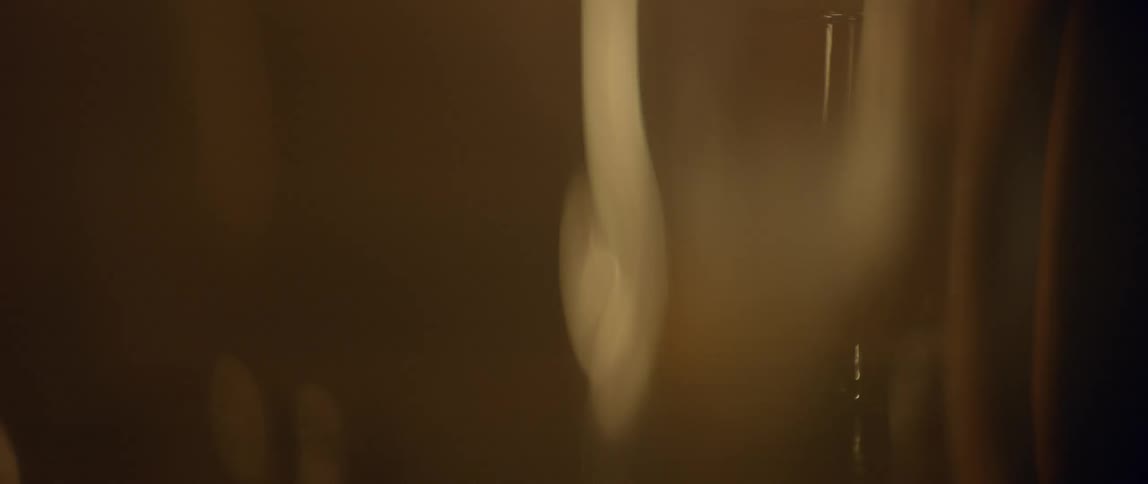 A bar glass with ice and a drink sits undisturbed