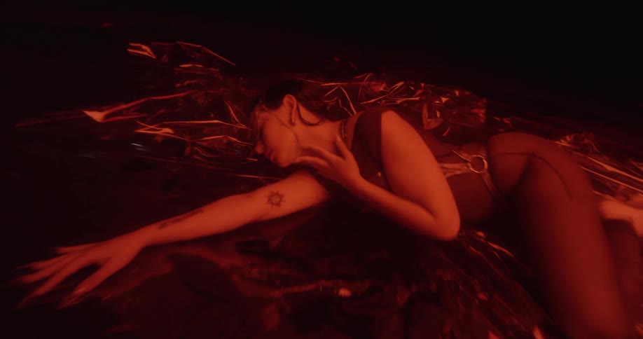 A woman lying on a floor and rubbing all over herself