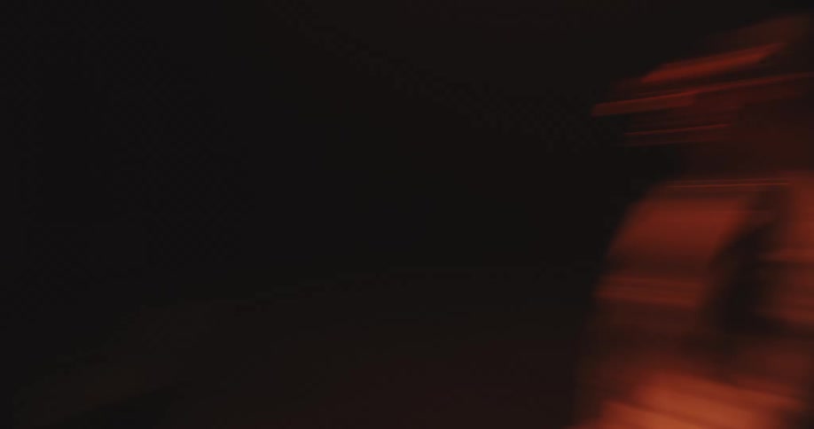 A camera spinning from a central spot amongst a person below orange lighting.