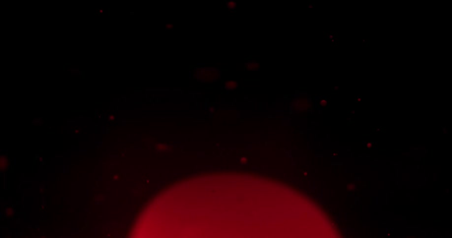Red liquid falls in the dark water