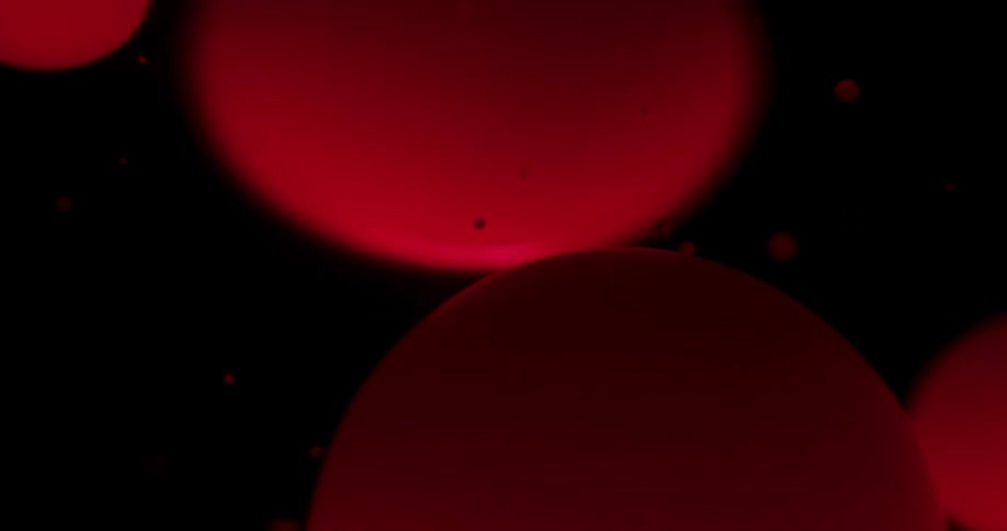 Spheres of orange sink and float in liquid
