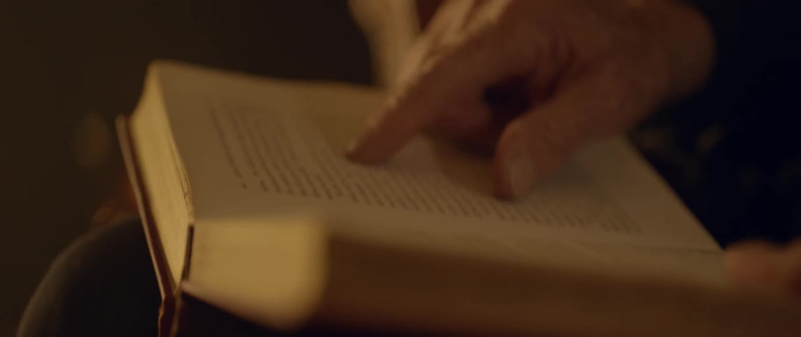 Person uses a finger to follow text in a book