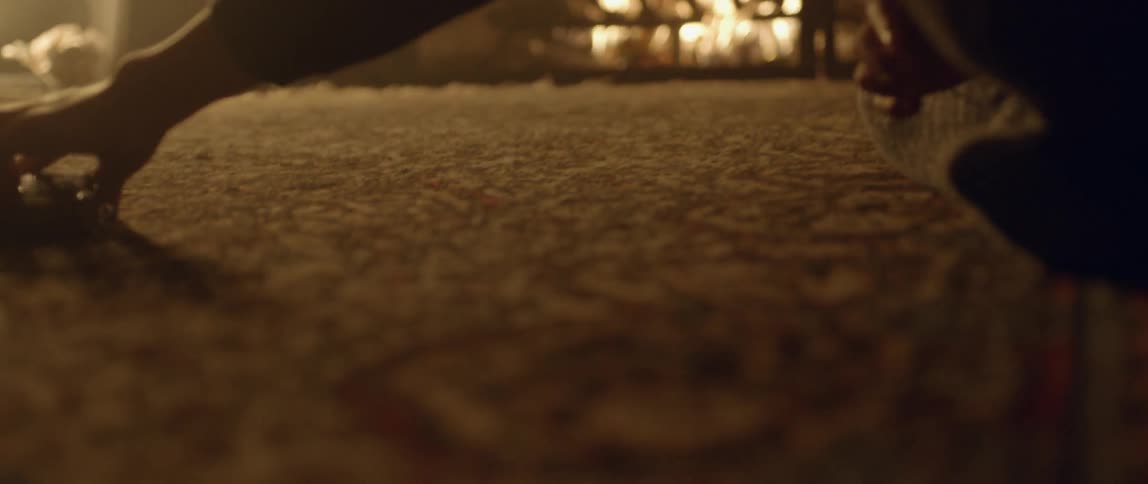 Toy race car being moved across the carpet with a fireplace in the background