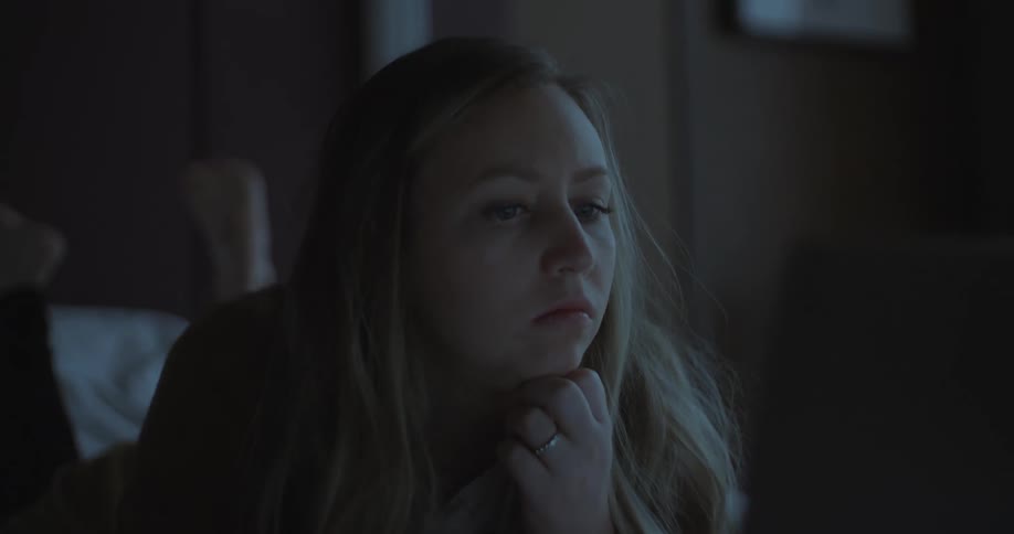 A woman looking at a tv in bed