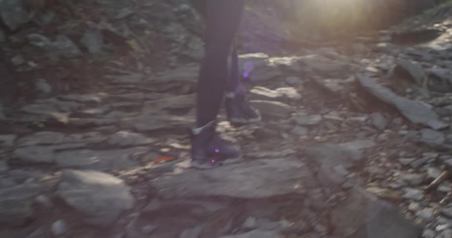 A woman is hiking up the rocky hill