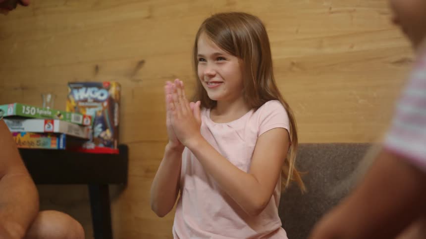 A family is laughing together and the little girl starts clapping
