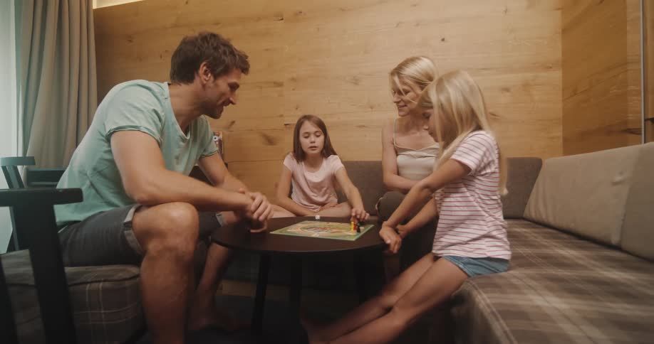 A family of four plays a board game