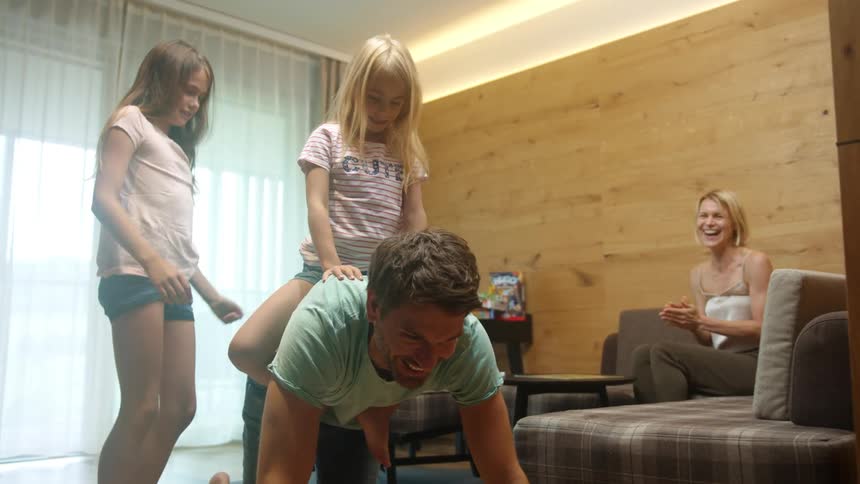 A father mother and daughters playing in a house