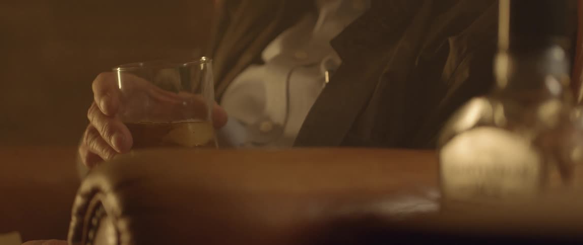 A man sits with a glass in his hand