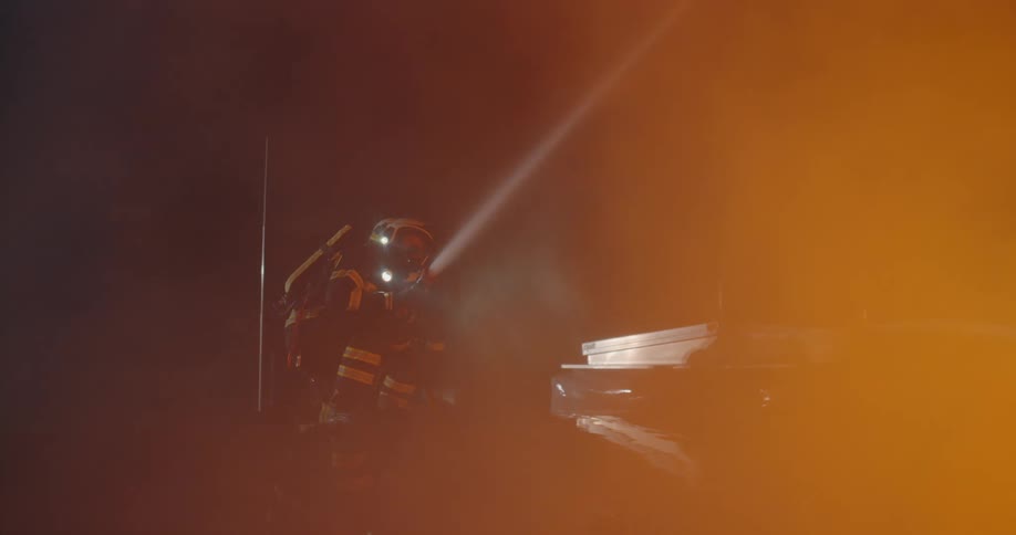 A firefighter with a jacket and helmet with smoke and fire in the foreground