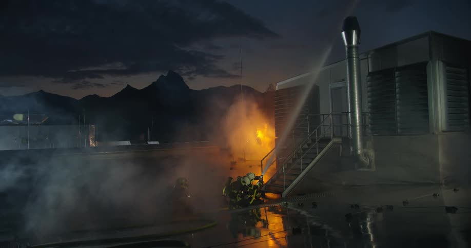 A group of firefighters spraying water onto a fire