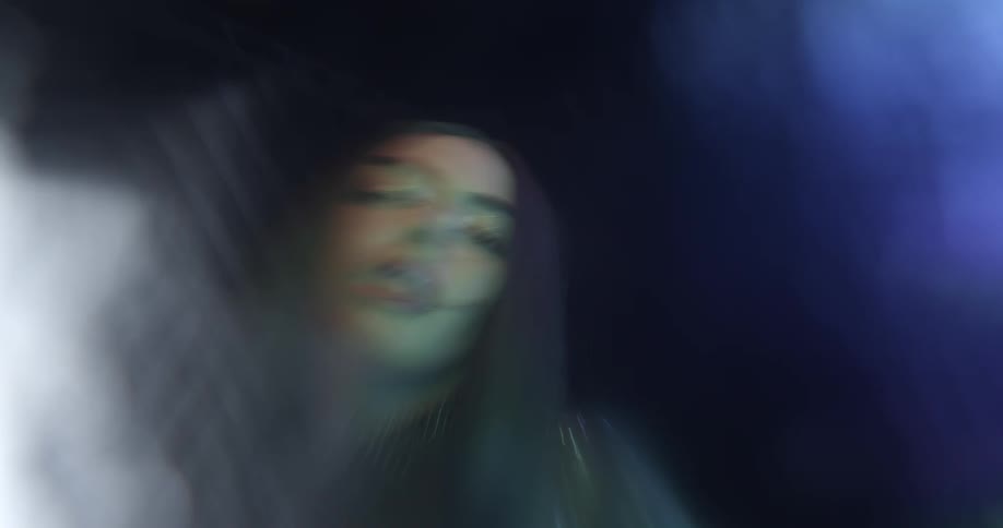 A woman dancing in a room with lights in the background