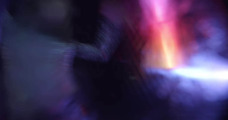 A woman dancing in a room with lights in the background