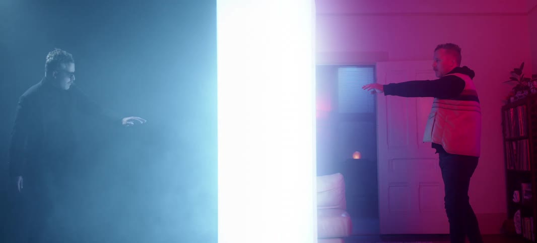A man on the blue side and a man on the red side move towards the middle white area
