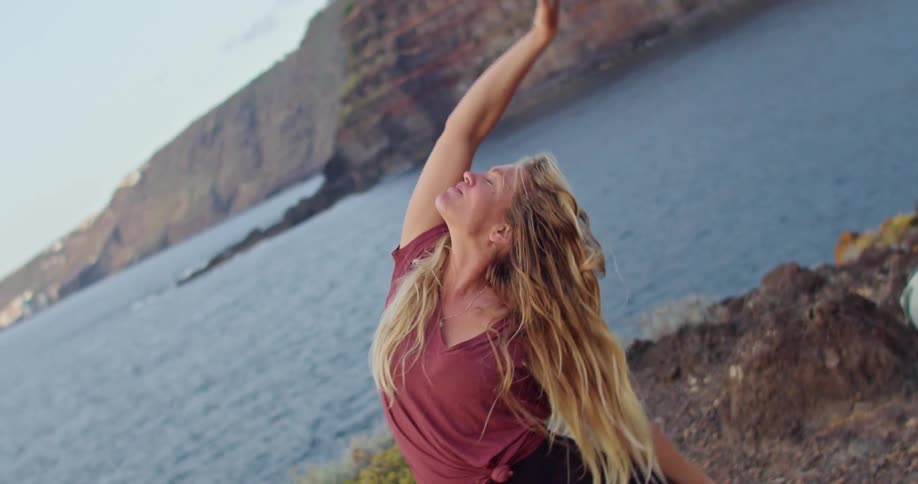 A woman doing yoga outdoors on a cliff