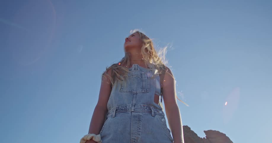 A girl is standing outside with a mountain peak as a backdrop