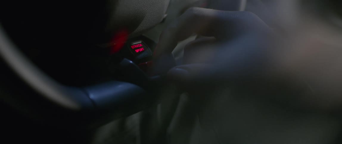 A hand flips a switch in a vehicle